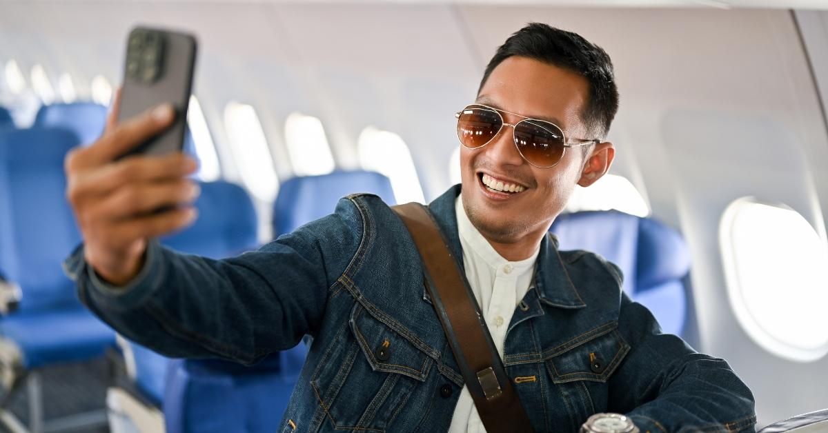 tourist taking selfie by his smartphone during the flight