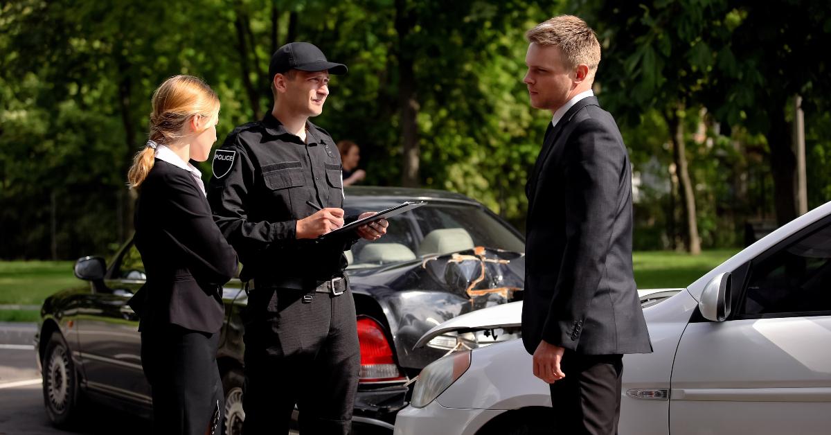 car drivers and policeman near wrecked autos
