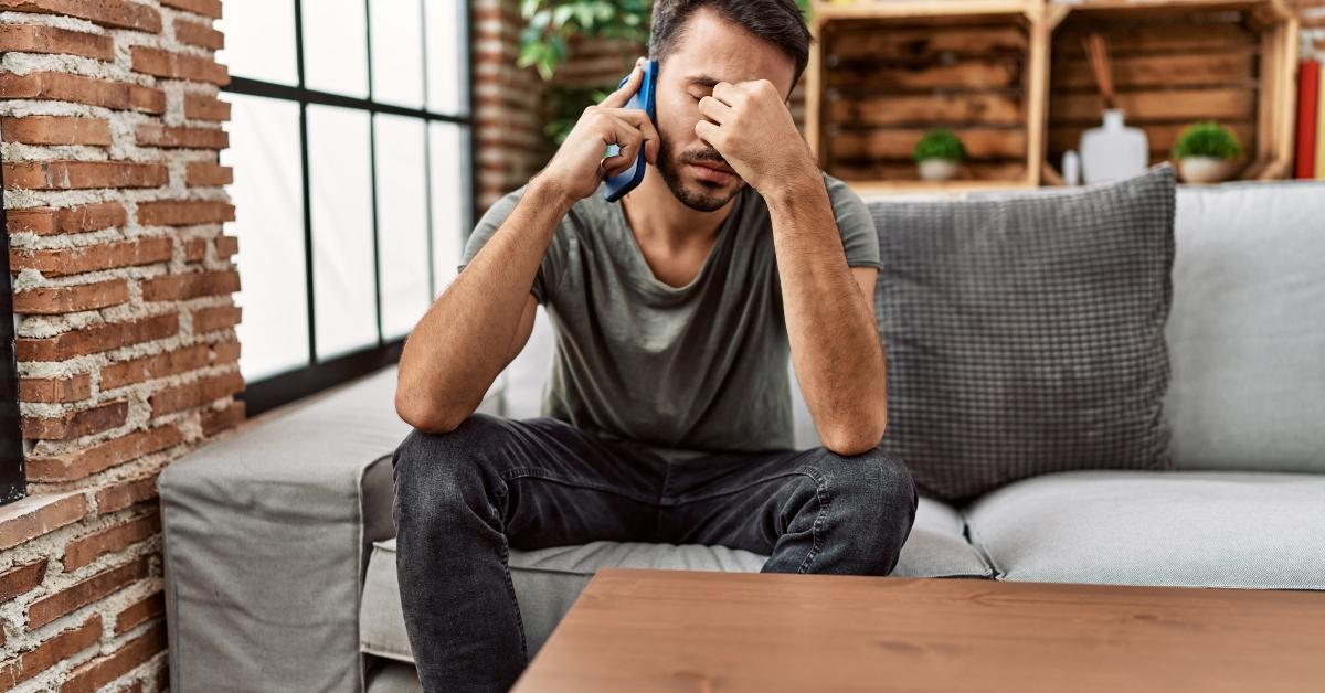 man worried talking on the smartphone at home