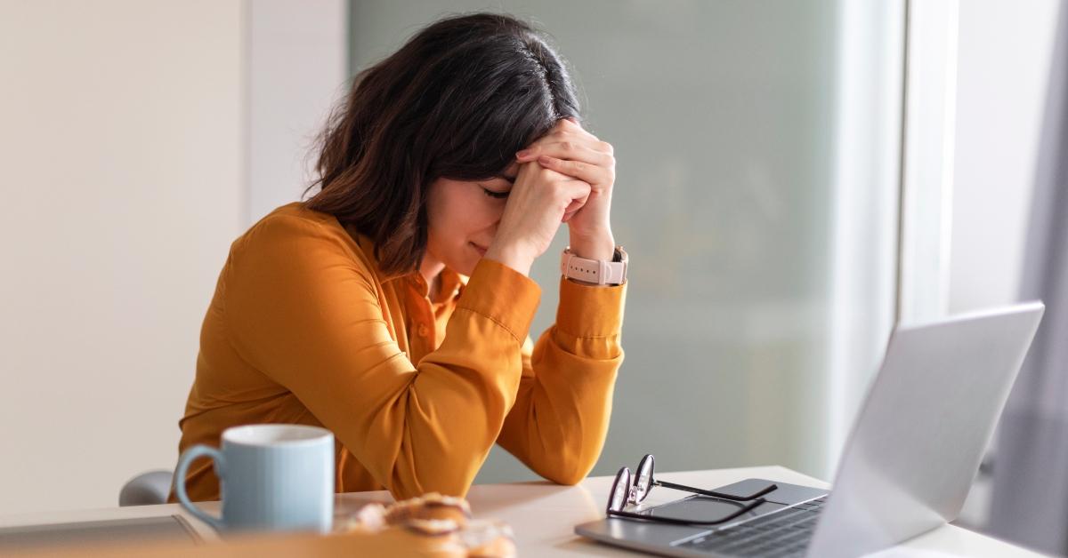 depressed woman sitting at desk with laptop
