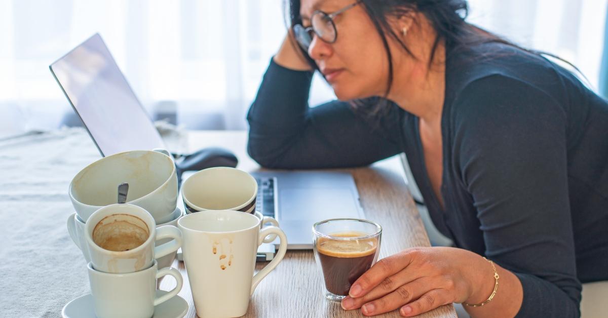 woman holding a cup of coffee sitting tired