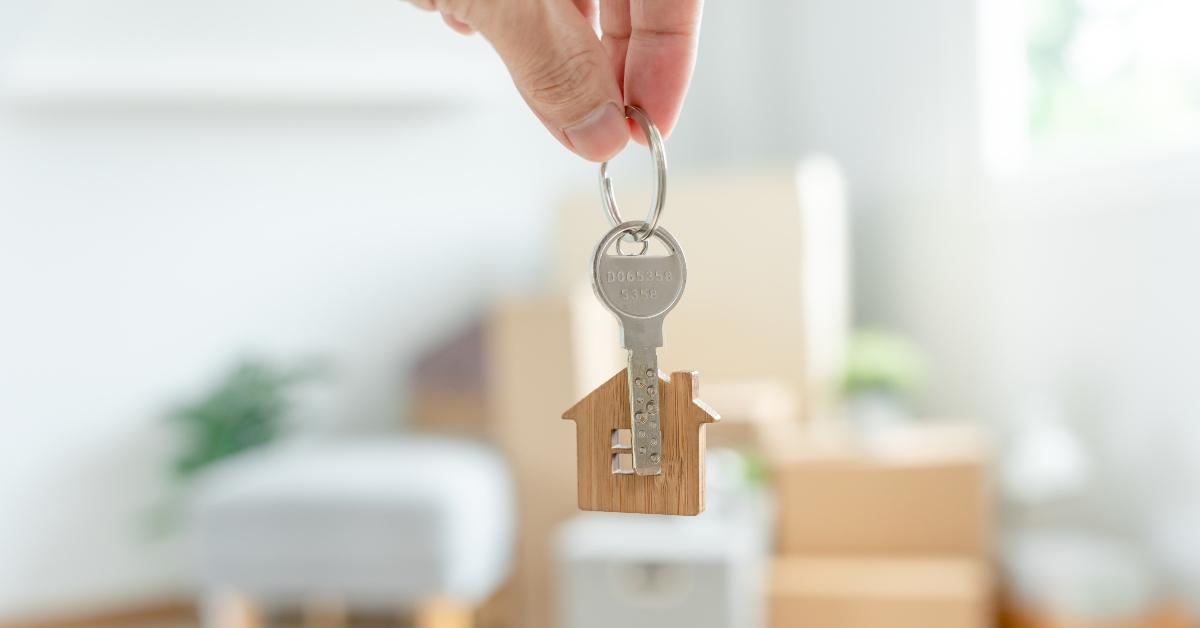woman holds key house keychain