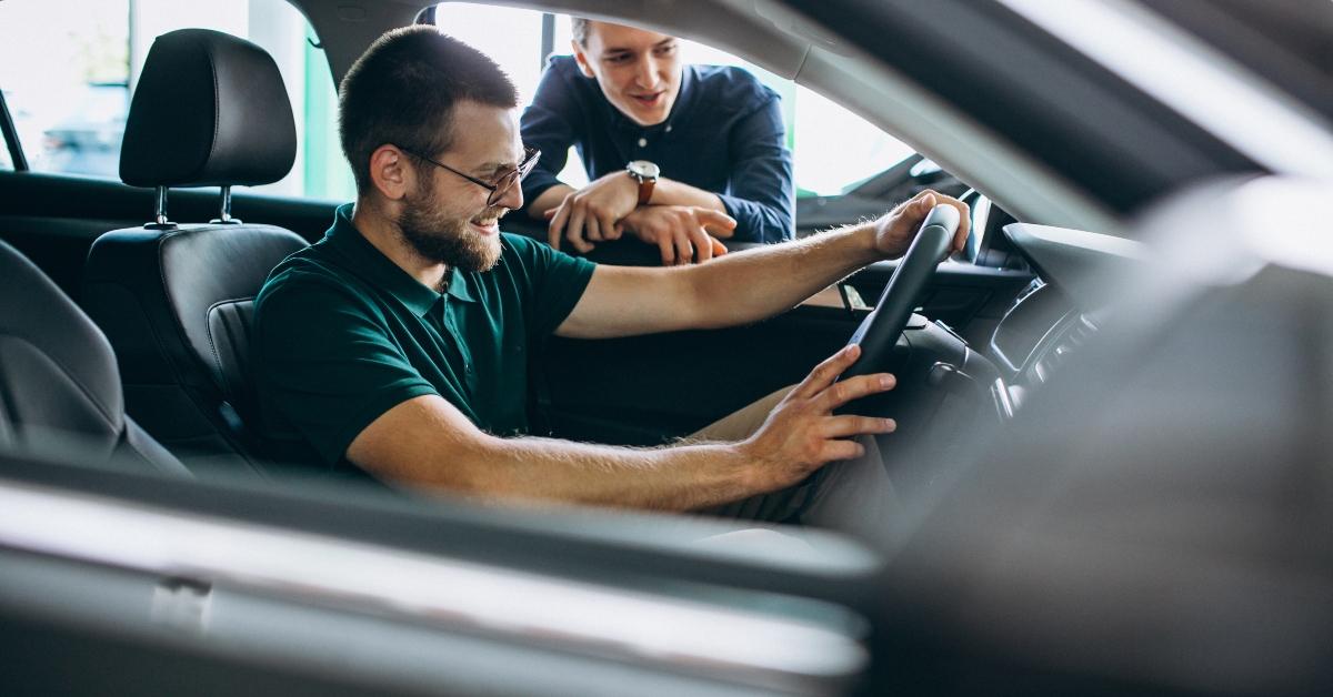 young man testing new car at a showroom