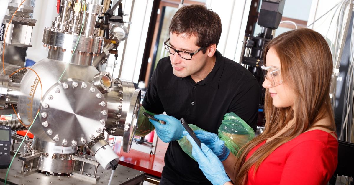 scientists working with laser deposition chamber