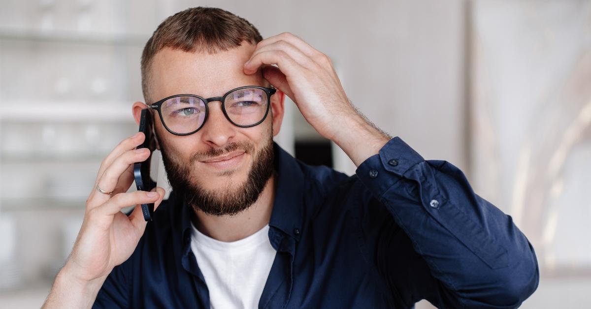 young man in glasses talks by phone makes decision