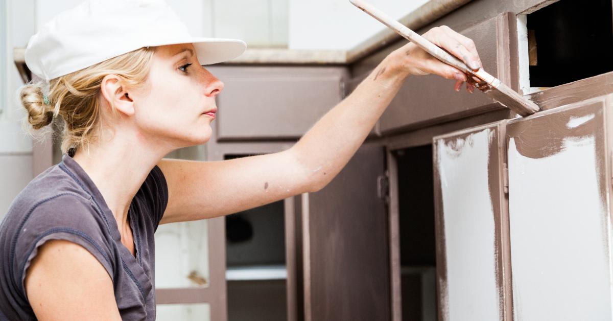 woman painting kitchen cabinet