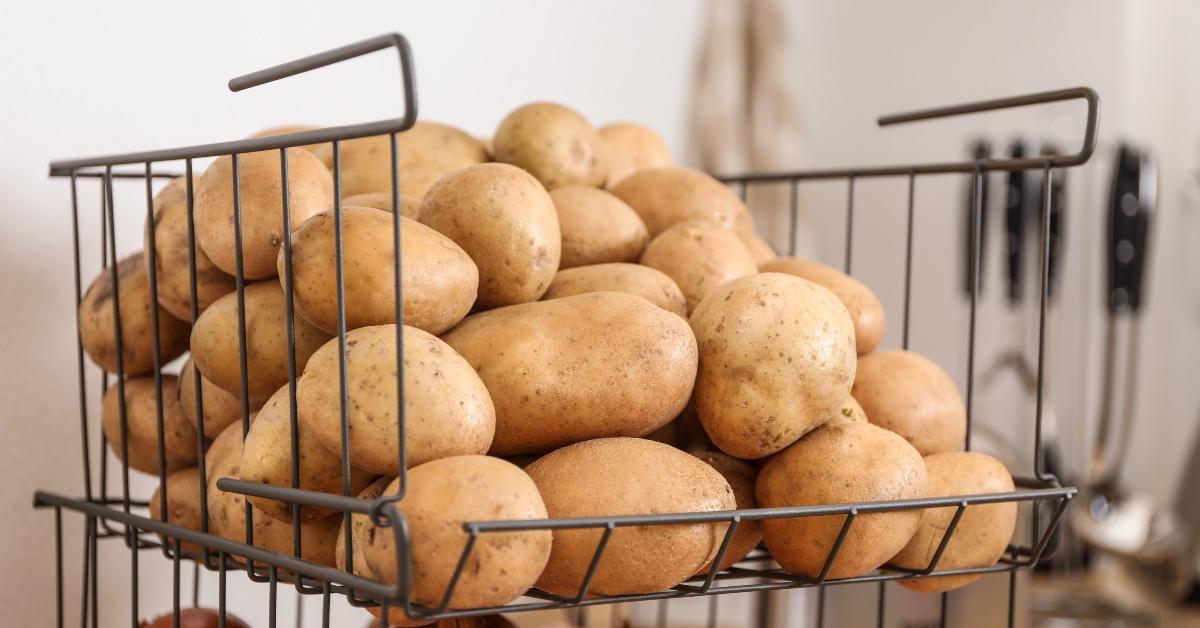 container with potatoes and onions in kitchen