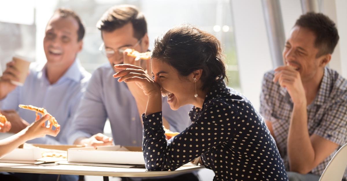 woman laughing at funny joke eating pizza