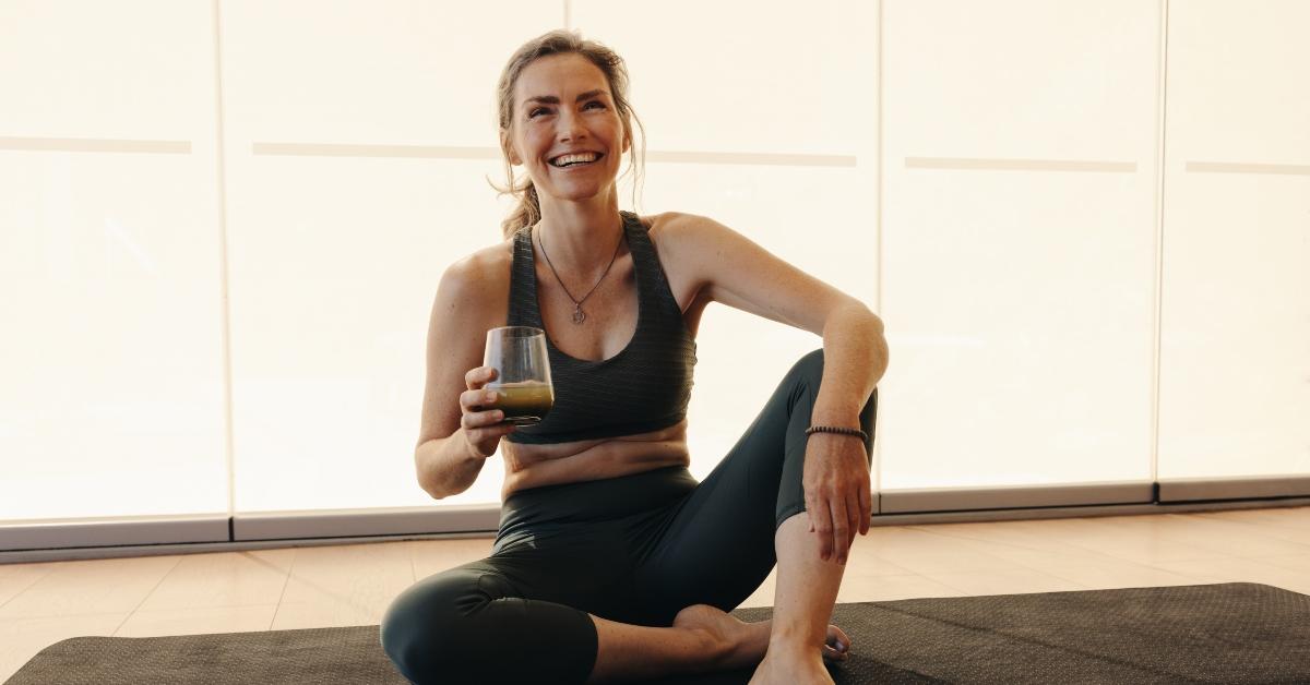 senior woman having green juice while working out