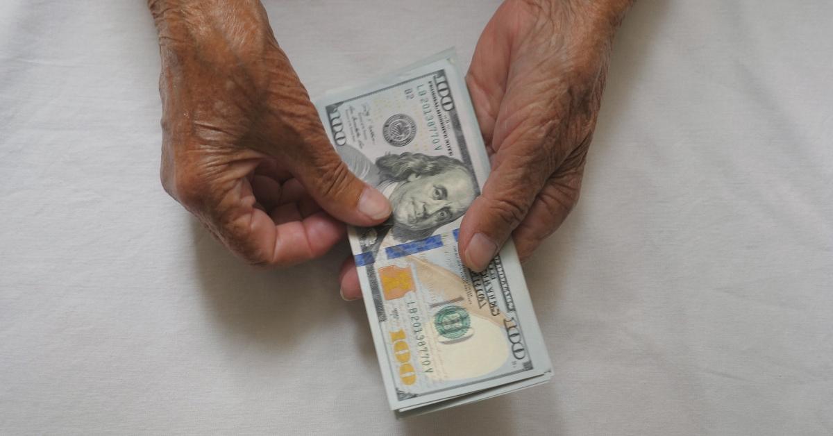 wrinkled female hands holds cash