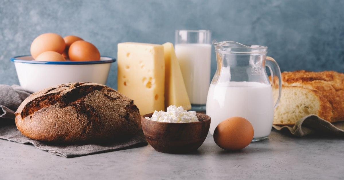 eggs flour, cheese milk and bread on table with grey background at back