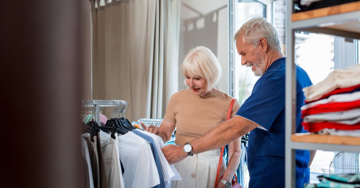 happy senior couple choosing shirts while shopping at store