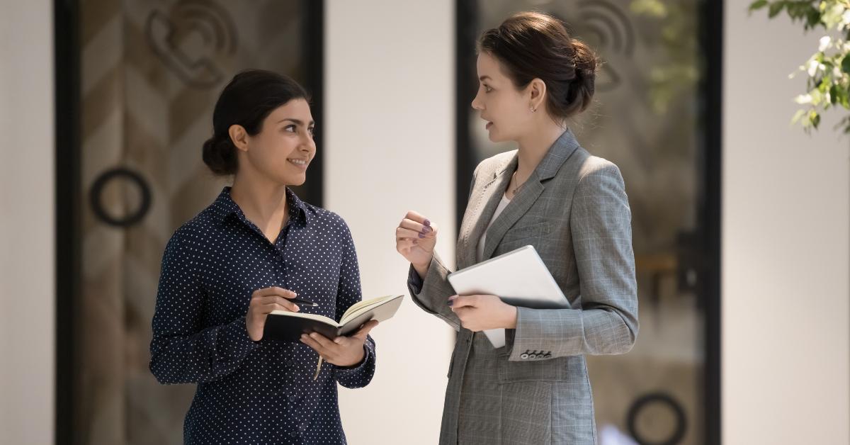 businesswomen stand in office hallway and talking