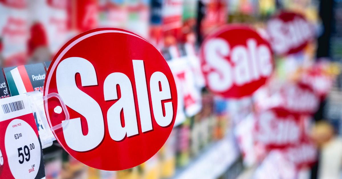 grocery store with products on shelves having huge sale signs in red color