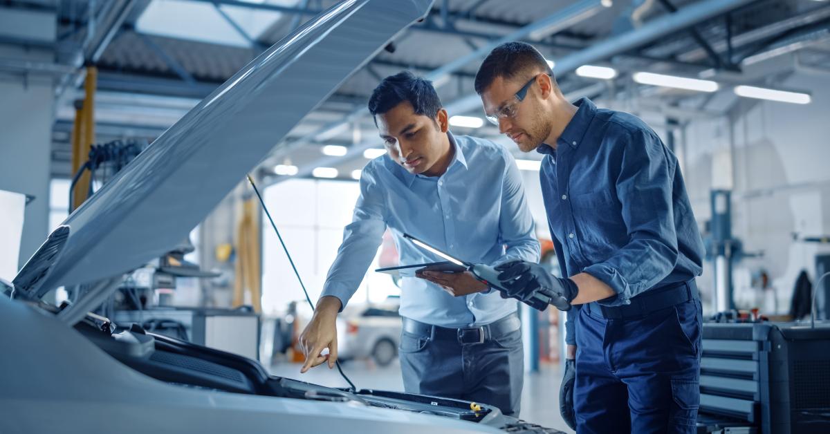 manager checks car engine 