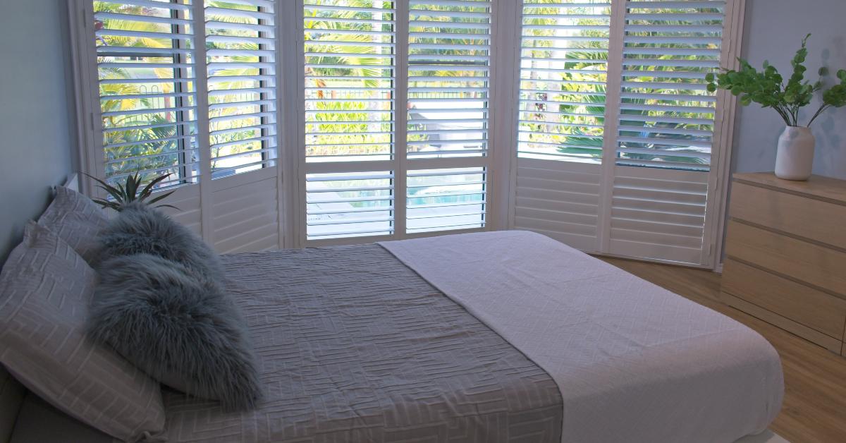 luxury white indoor plantation shutters in bedroom