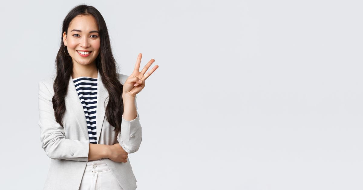 woman showing number three and smiling