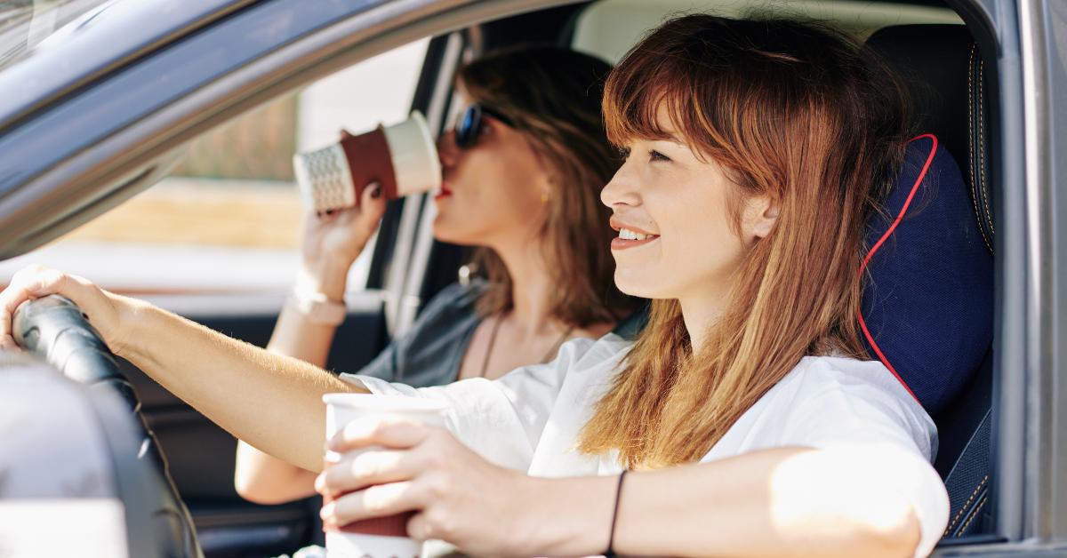 friends drinking take out coffee while riding car