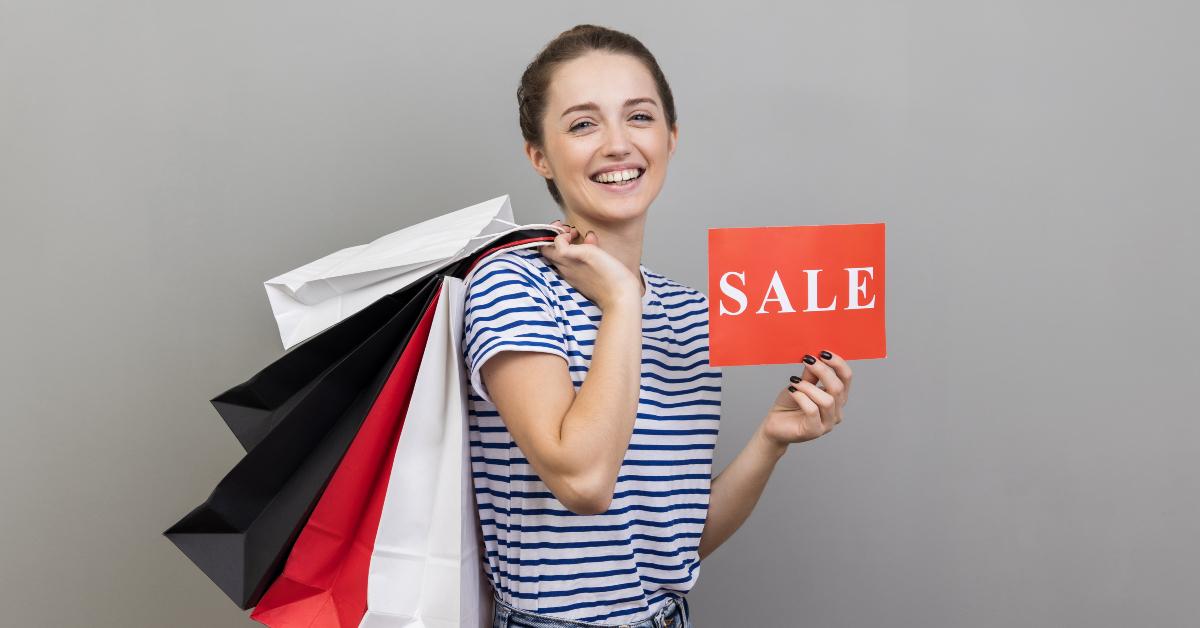 woman with shopping bags and sale card