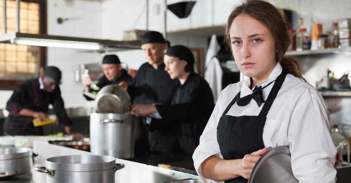 tired and upset waitress in kitchen of restaurant
