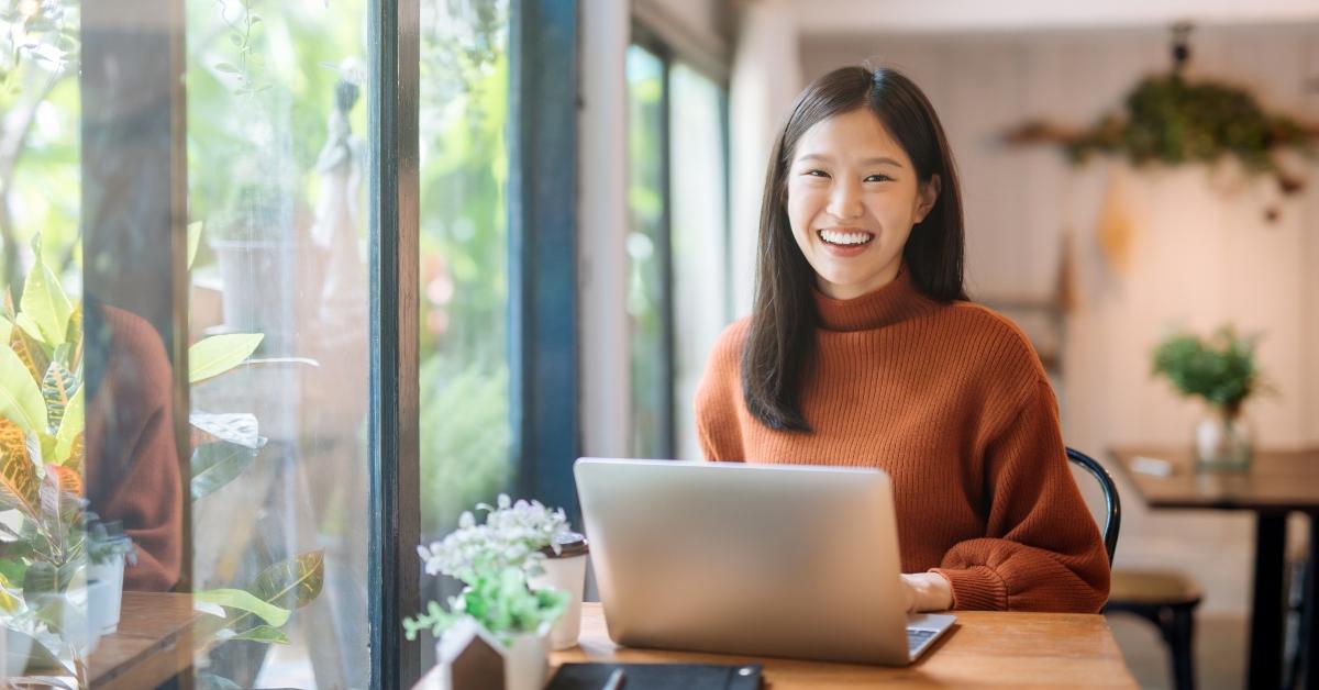 asian girl working at a coffee shop with a laptop
