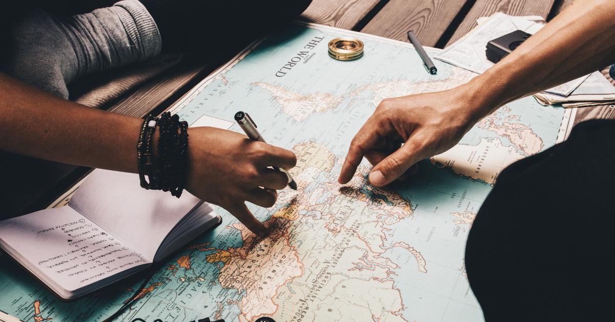 couple planning vacation using the world map