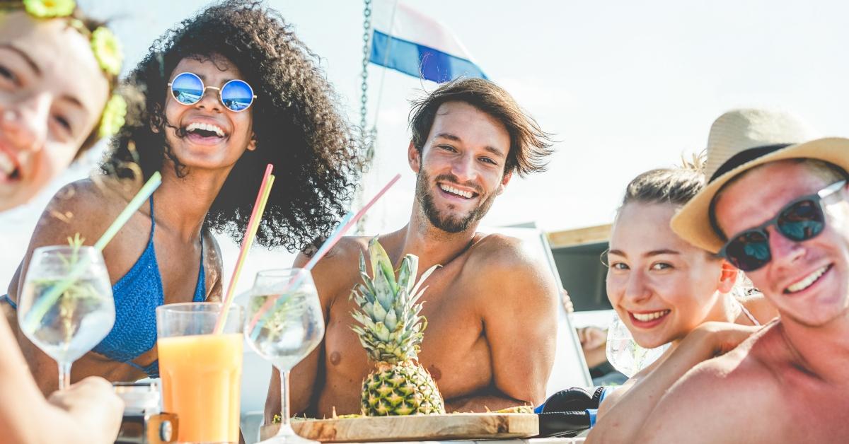 friends drinking tropical cocktails at boat party