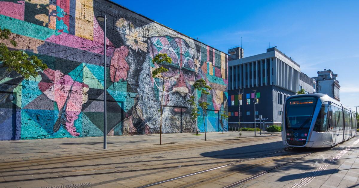 rio de janeiro walls with murals besides train during day time