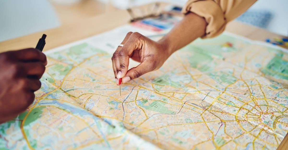 woman's hand pointing on mark on cartography planning 