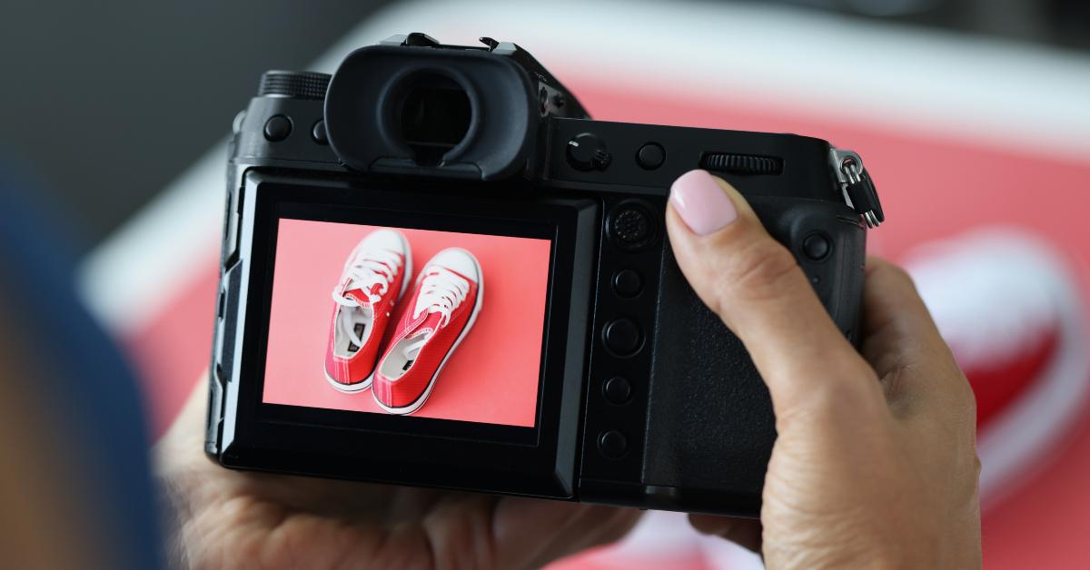 woman photographing red sports shoes