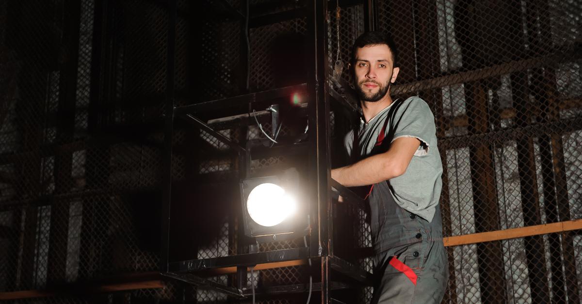 lighting engineer adjusts the lights on stage behind the scenes