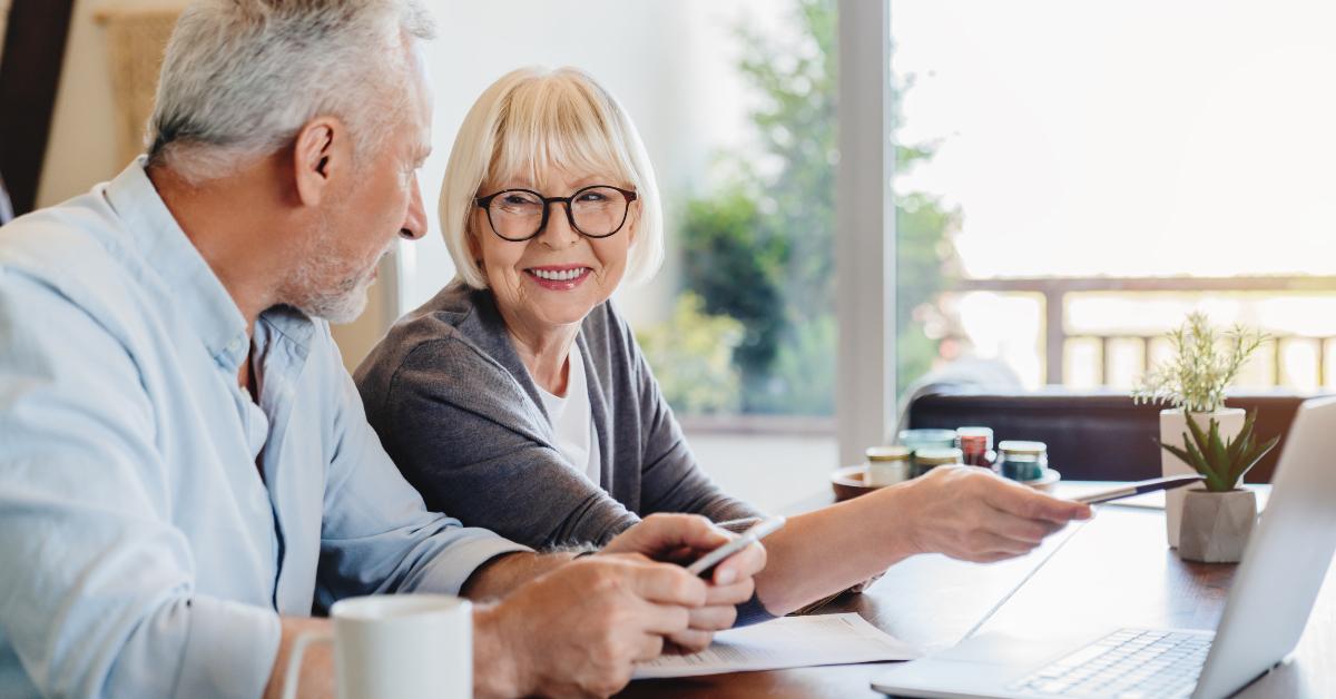 senior couple doing home finances using laptop indoors