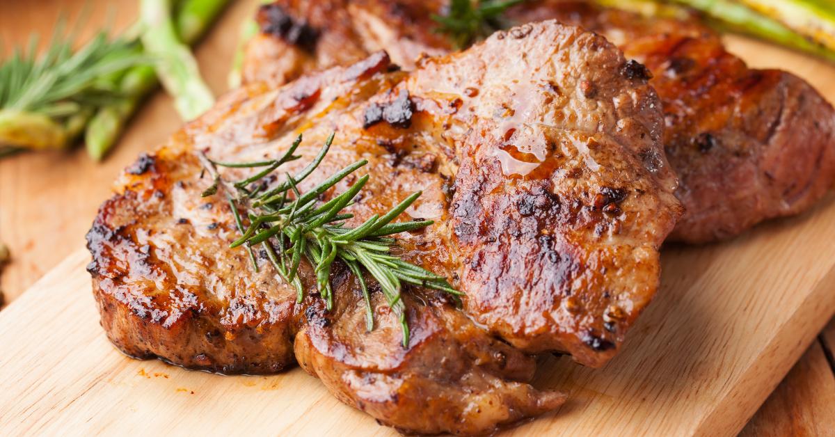 grilled pork chop with rosemary on wooden board