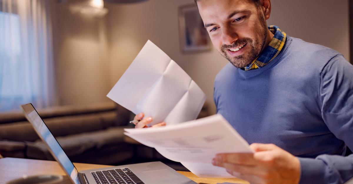man holding bills in his hands and calculating payment