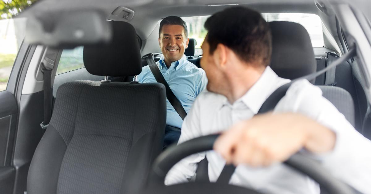 middle aged male passenger talking to car driver