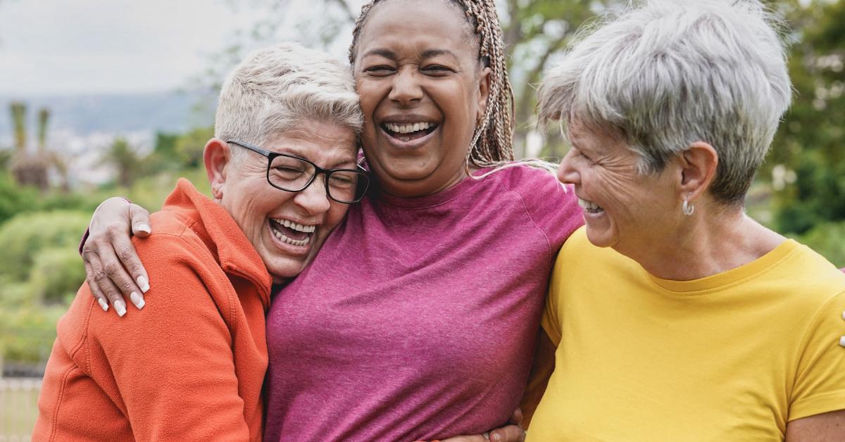 multi ethnic senior woman talking and laughing together in park