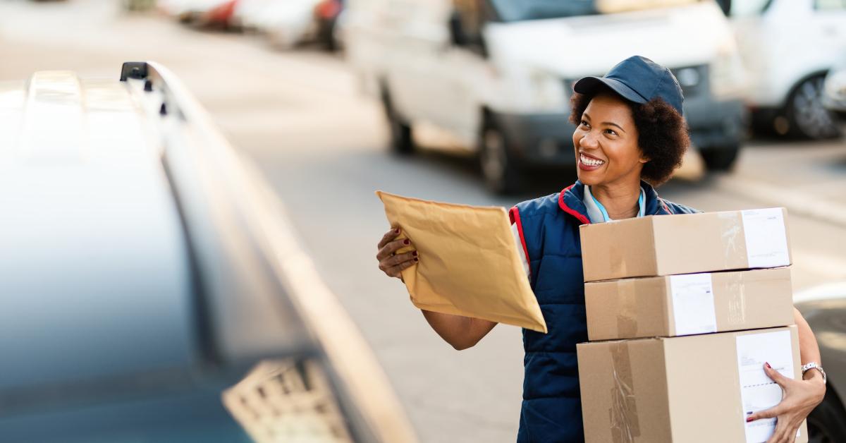 black postal worker delivering packages in the city