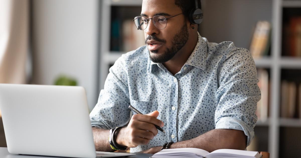 businessman wears headphones to study online