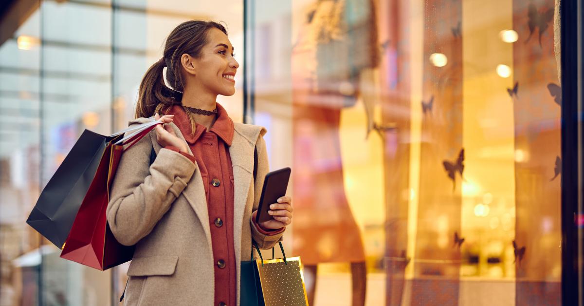 woman with shopping bags looking at store windows