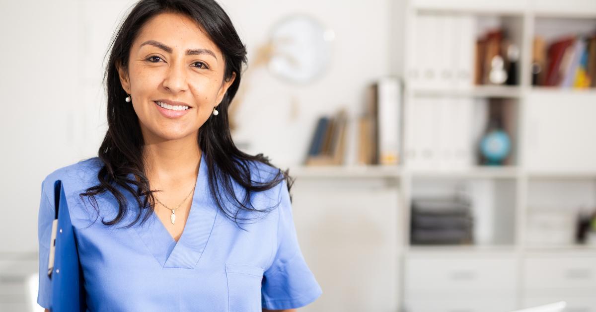 health worker wearing blue uniform standing in medical office