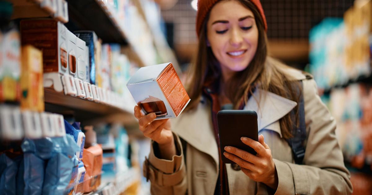 woman using cellphone while shopping for skin care products