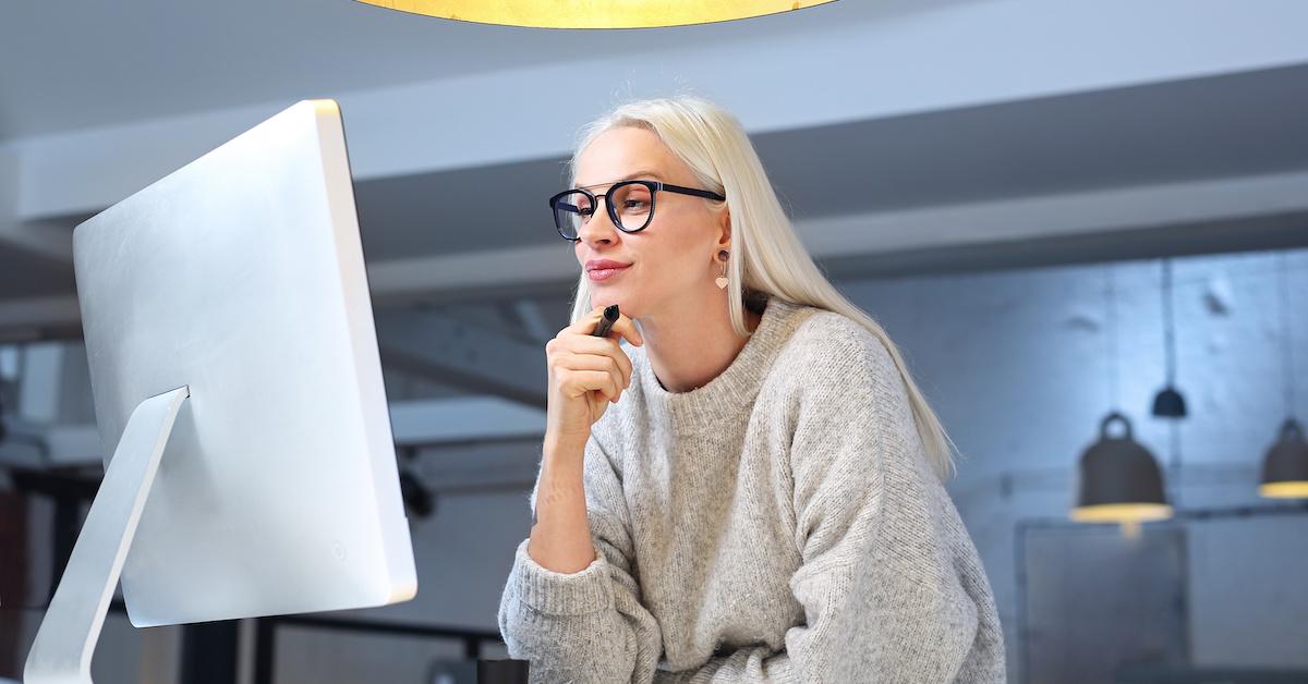Woman wearing glasses and looking at a computer monitor
