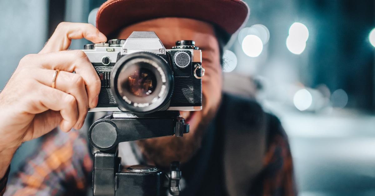 man taking photo using vintage camera