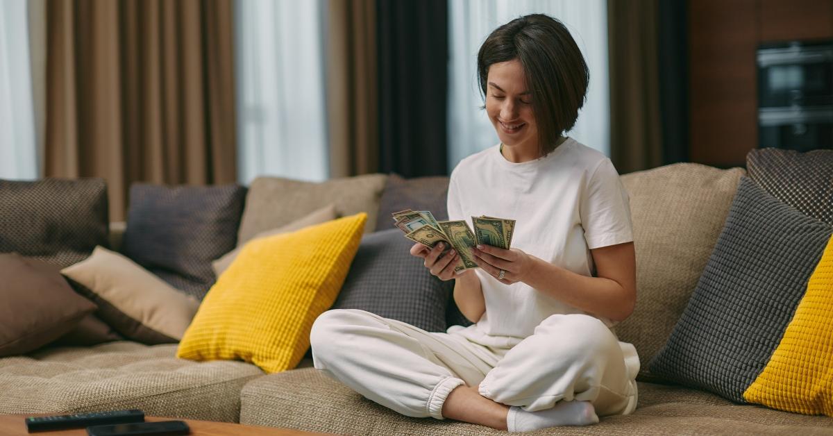 happy young woman counting cash