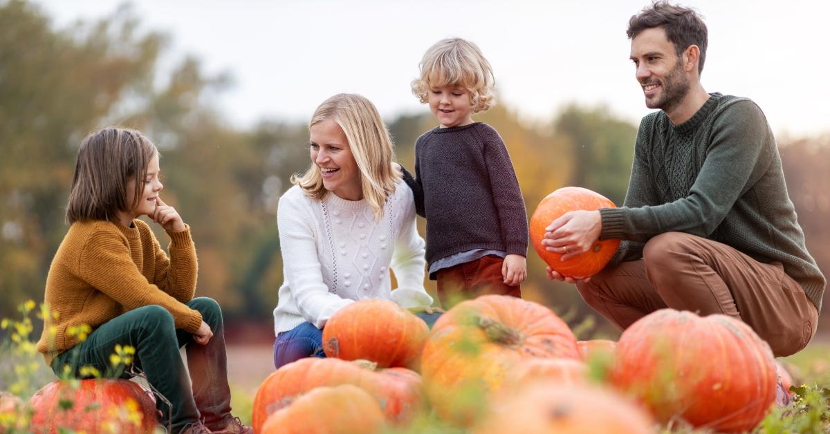 family in pumpkin patch field