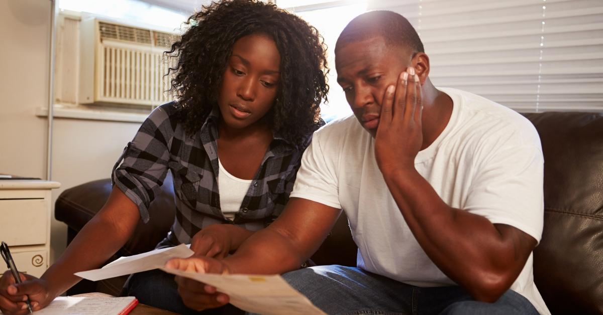 worried young couple sitting on sofa