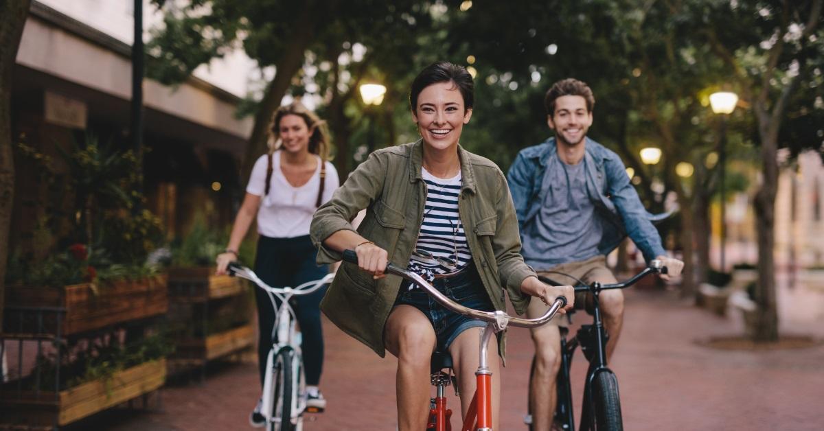 happy friends cycling in city