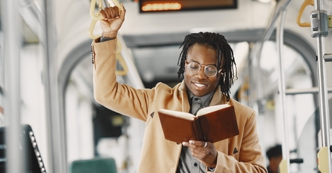 man reading book on train