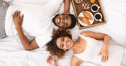 Couple enjoying hotel breakfast in bed