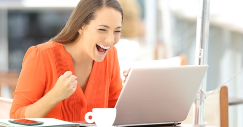 Woman cheering at computer screen